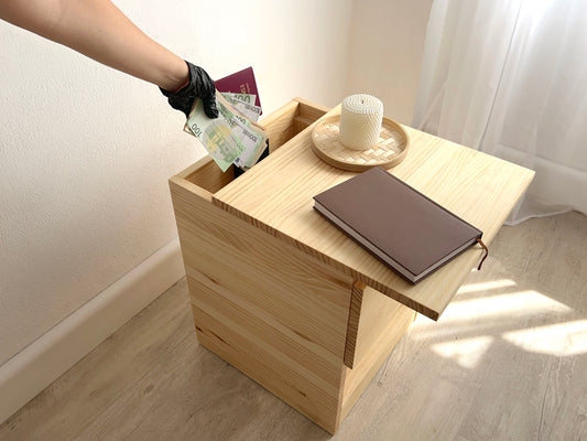 Mesita de pino macizo Beetle Wood con compartimento secreto integrado y apariencia convencional en ambiente de habitacion con decoracion guardando dinero y pasaporte en compartimento camuflado
