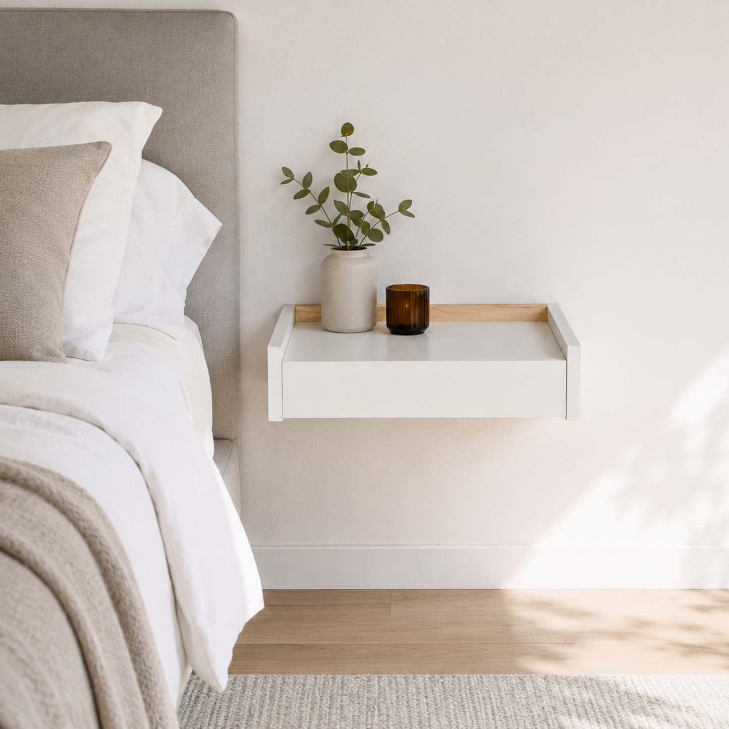 Mesita flotante Beetle Float blanca instalada junto a cama en dormitorio minimalista moderno.