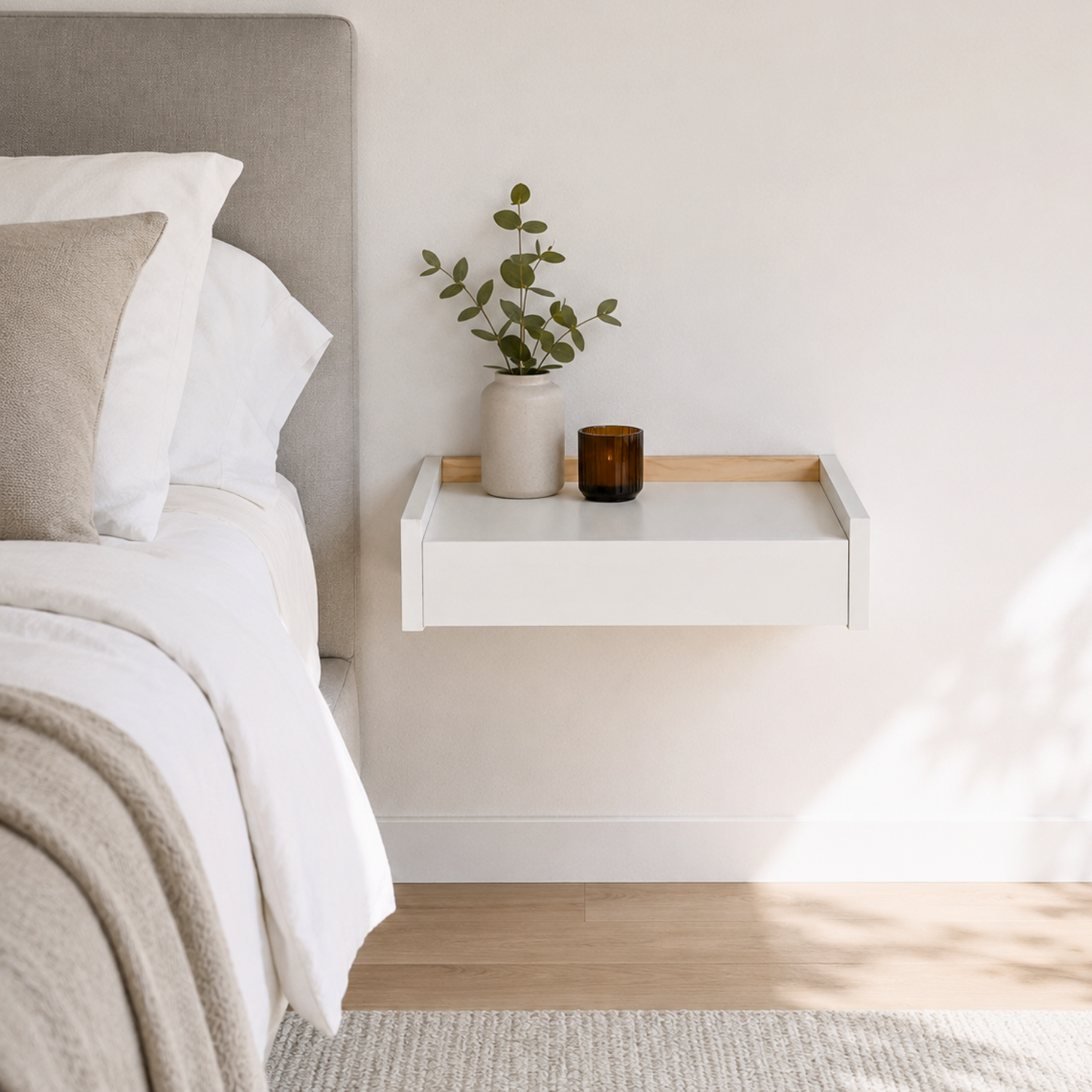 Mesita flotante Beetle Float blanca instalada junto a cama en dormitorio minimalista moderno.