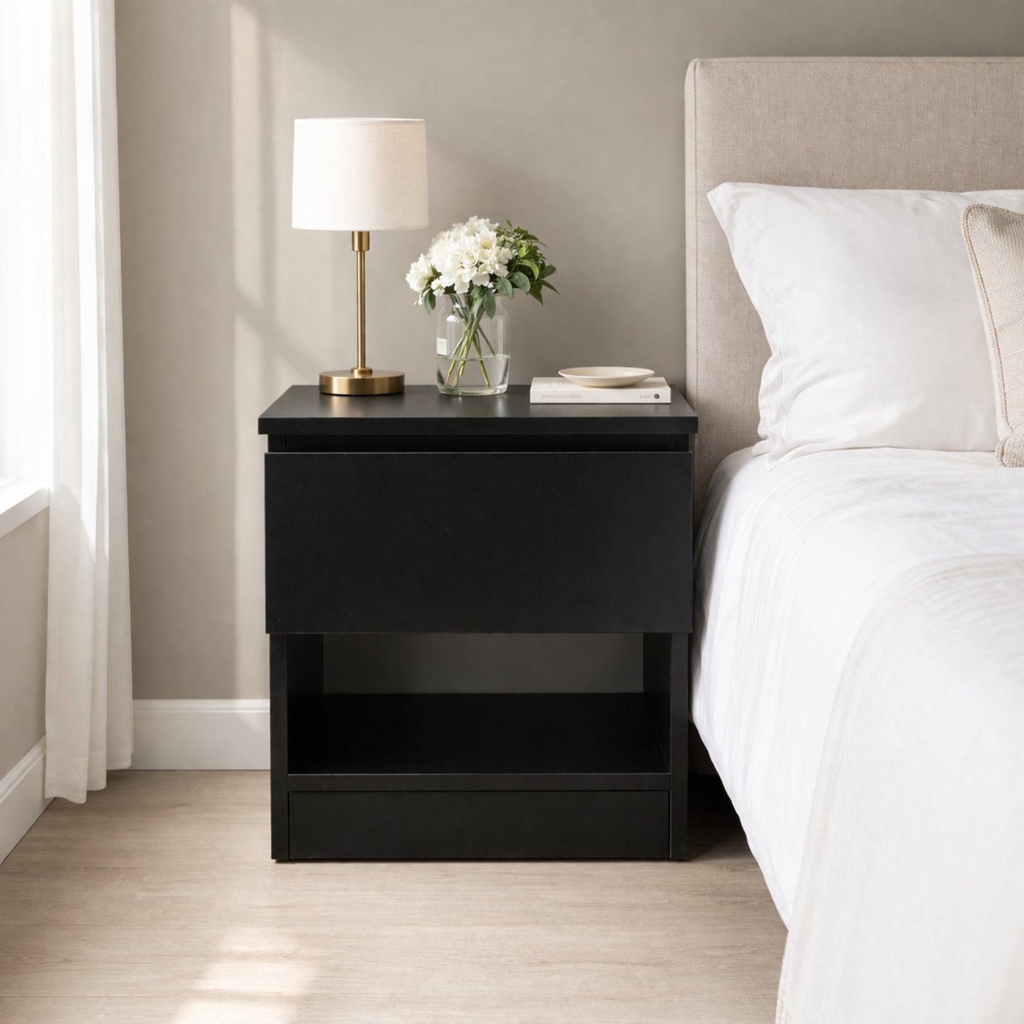 mesita de noche negra con compartimento oculto instalada junto a la cama con diseño moderno y almacenamiento discreto
