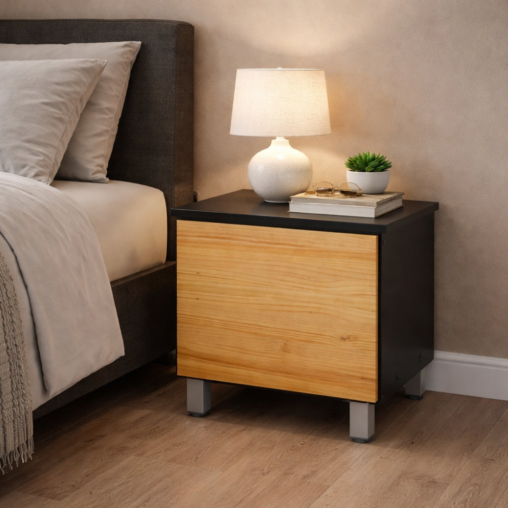 mesita de noche moderna con acabado en madera y negro colocada junto a la cama con lámpara y decoración encima