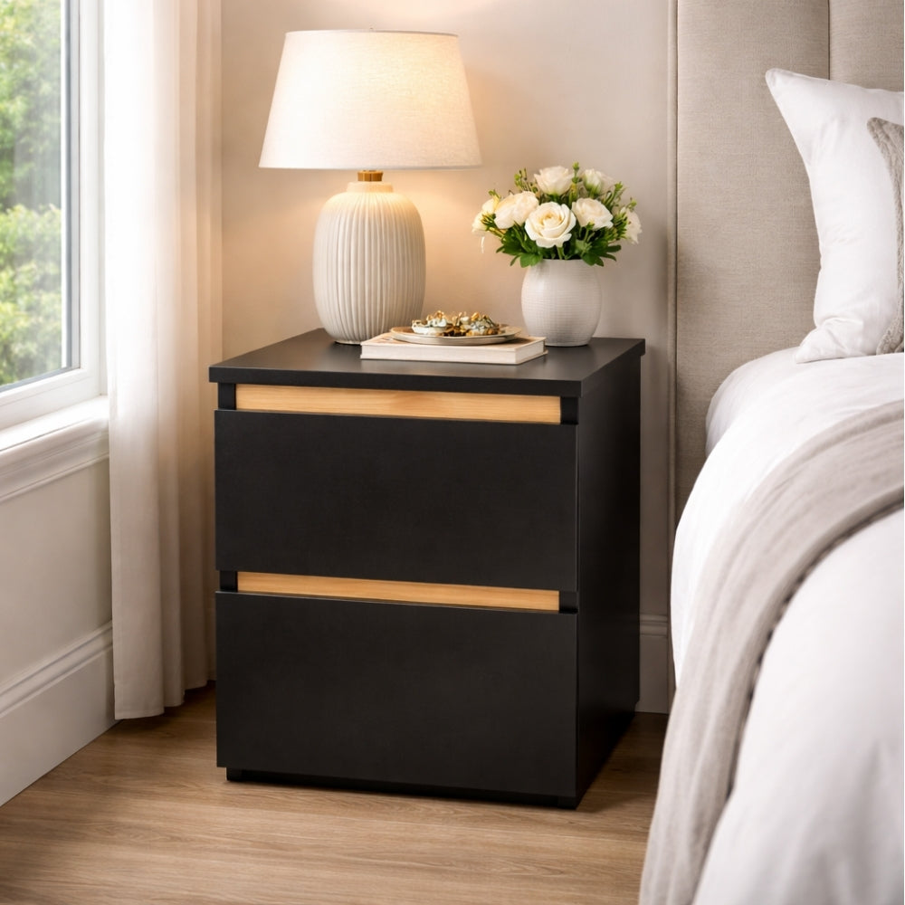 mesita de noche negra moderna junto a cama con lámpara y decoración en dormitorio elegante y funcional